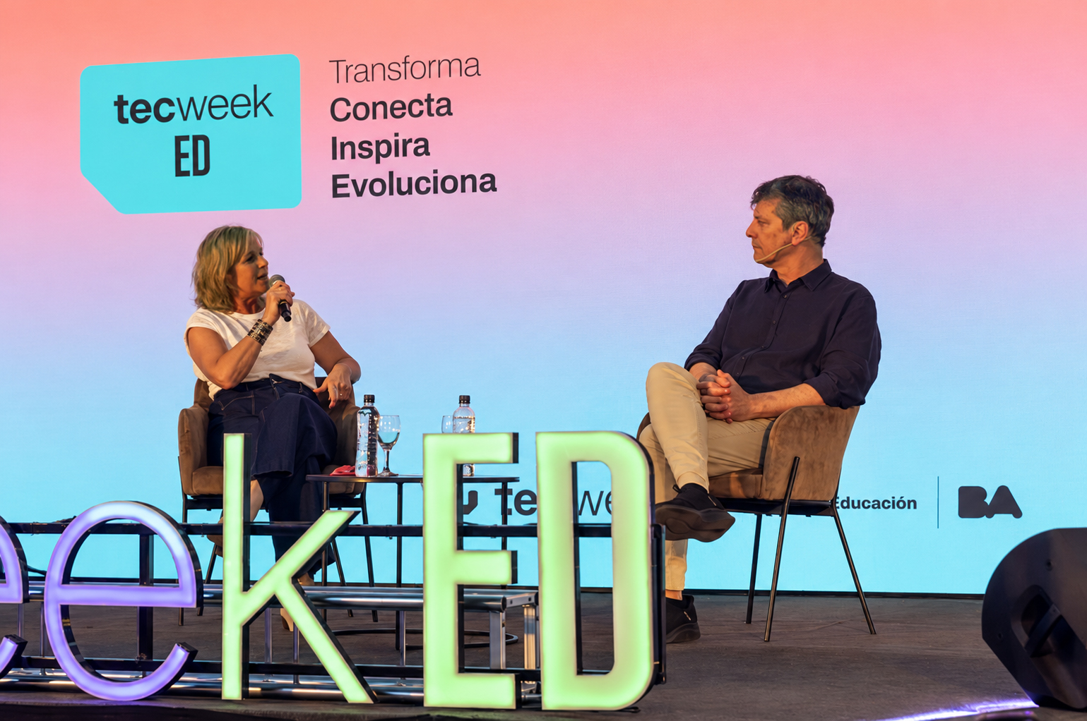 Panel de discusión con varias personas conversando alrededor de una mesa