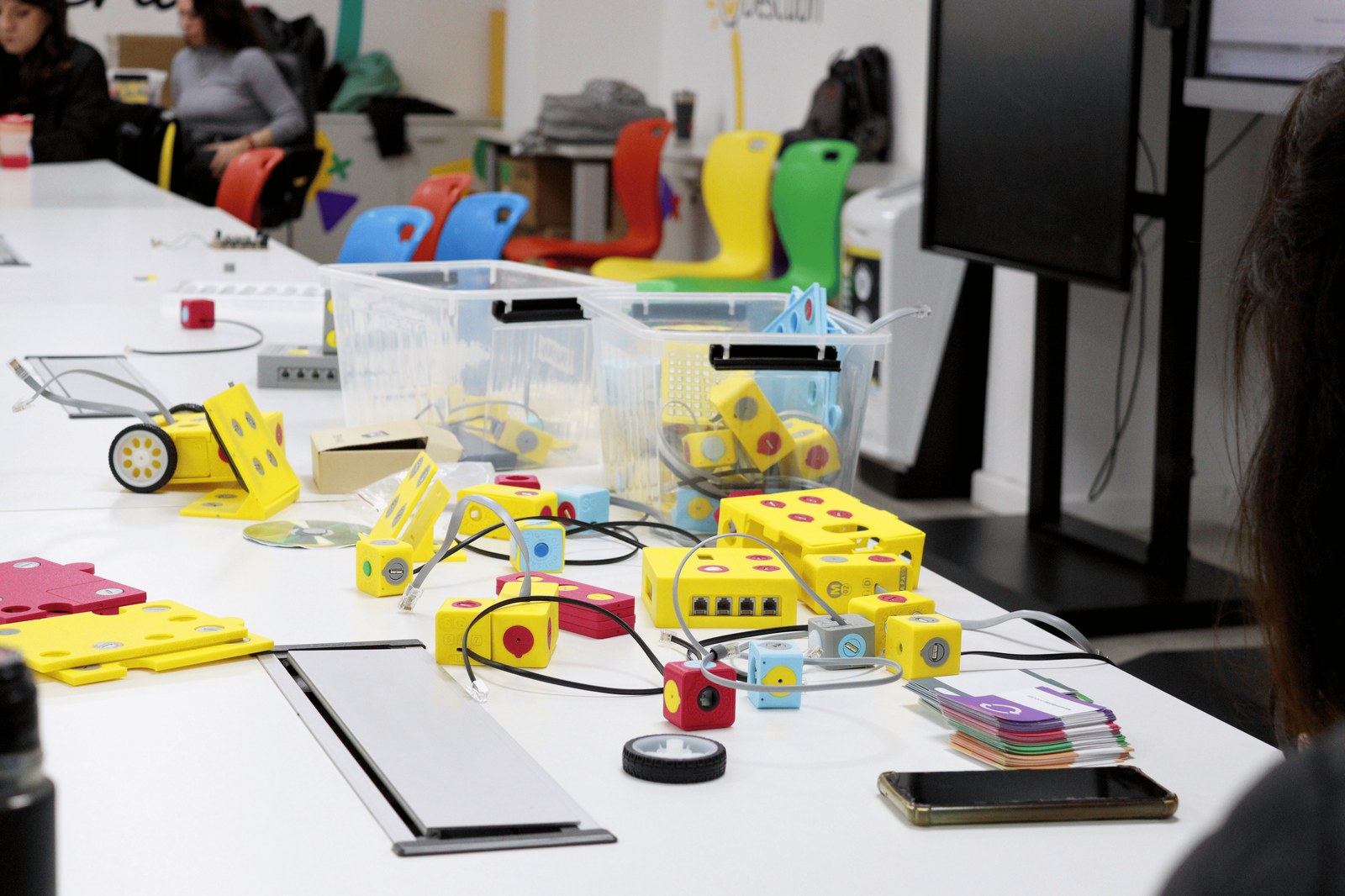 Manos armando un robot con componentes electrónicos en un taller maker